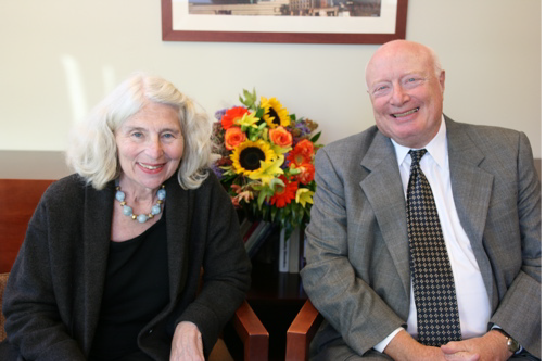 Marilyn and Larry Cohen smiling with flowers between them