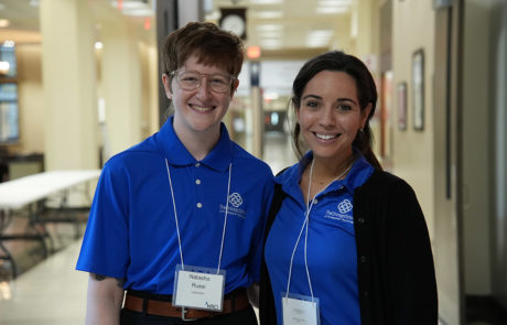 two women in blue shirts smiling