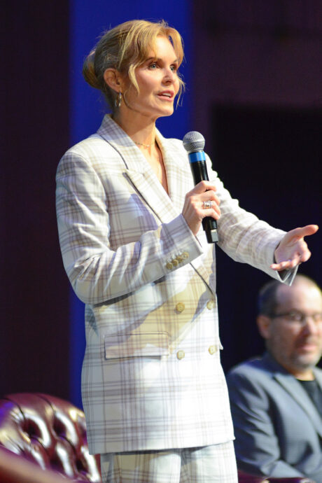 woman in white plaid outfit holding microphone