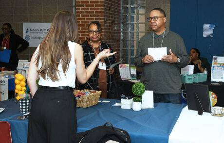 woman talking with two people wearing glasses at a table