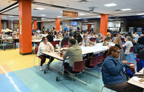 people eating and talking in a large cafeteria