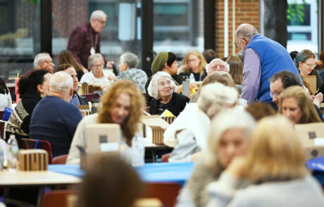 group of people talking and eating in a cafeteria