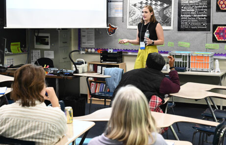 woman speaking to classroom while holding a water bottle