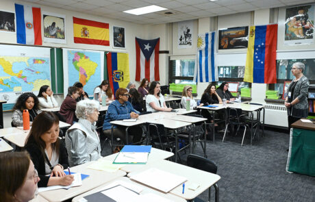 woman with short gray hair speaking to a classroom