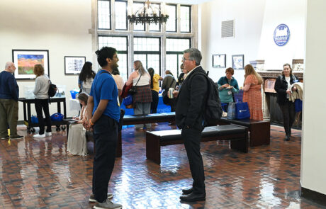 man in blue shirt talking to man in suit