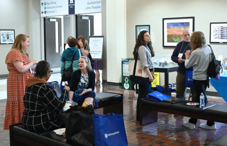 group of people talking with blue swag bags